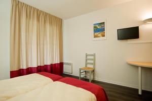 um quarto de hotel com duas camas e uma secretária em VVF Pays Basque Sare La Rhune em Sare