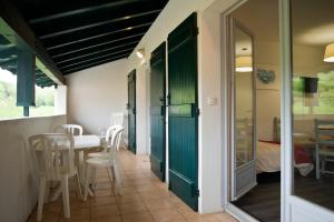 um quarto com uma mesa e cadeiras e uma porta verde em VVF Pays Basque Sare La Rhune em Sare