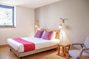 - une chambre avec un lit doté d'oreillers violets et d'une chaise dans l'établissement Victoria Garden Bordeaux Centre, à Bordeaux