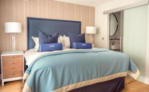 a bedroom with a large bed with blue pillows at Southampton Harbour Hotel & Spa in Southampton