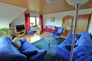ein Wohnzimmer mit einem blauen Sofa und blauen Stühlen in der Unterkunft Ferienwohnungen "Zur Friesen Freude" in Dornum