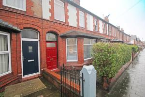 a red brick house with a red door on a street at Panton Road - Modern Classic Terrace in Chester