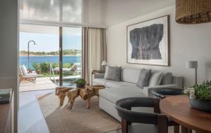 a living room with a couch and a table at Four Seasons Astir Palace Hotel Athens in Athens