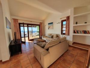 a living room with a couch and a view of the ocean at 2 bedroom villa 'The Bungalow' with private heated pool. in Puerto del Carmen