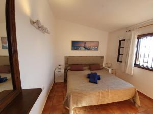 a bedroom with a bed with blue pillows on it at 2 bedroom villa 'The Bungalow' with private heated pool. in Puerto del Carmen