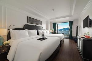 um quarto com 2 grandes camas brancas e uma janela em My Gallery Boutique Hotel & Spa em Sa Pa