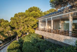 a house on a hill with trees in the background at Four Seasons Astir Palace Hotel Athens in Athens