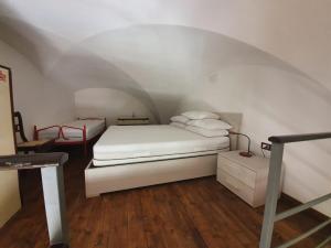 a bedroom with a white bed in an attic at Il Borgo Apartment in Gaeta
