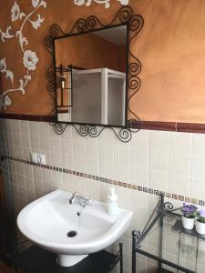 uma casa de banho com um lavatório e um espelho em Casa Puerta de la Sierra em Higuera de la Sierra