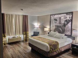 a hotel room with a bed and a large painting on the wall at Super 8 by Wyndham Georgetown in Georgetown