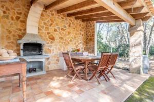 un patio con mesa, sillas y chimenea en Marina Ses Covetes, en Campos