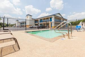 uma piscina com escorrega em frente a uma cerca em Days Inn by Wyndham Houston East em Houston