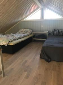 two beds in a room with a wooden floor at Joarsbo, Stuga 2, Gårdsstugan in Kalv