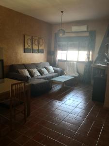 uma sala de estar com um sofá e uma mesa em Casa Puerta de la Sierra em Higuera de la Sierra