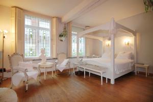 ein Schlafzimmer mit einem weißen Bett und Stühlen in der Unterkunft Suite " Mon Rêve " in Maastricht
