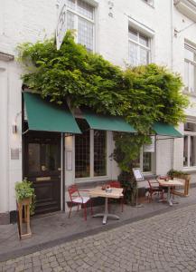 Suite " Mon Rêve " في ماستريخت: طاولة وكراسي خارج مبنى به نباتات