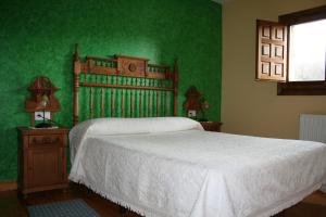 1 dormitorio con 1 cama con pared verde en Las Hoyas I y II en Tolbaños de Arriba