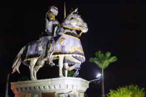 Una estatua de dos personas montando un caballo por la noche en Castelo de Itaipava - Hotel, Eventos e Gastronomia, en Itaipava