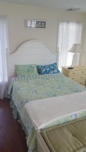 a bedroom with a bed with a blue and white comforter at 65 East Atlantic Way, Lavalette, New Jersey in Lavallette