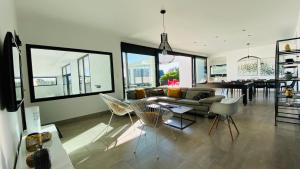 a living room with a couch and chairs and a table at Villa Pool and Beach Bretagne in Plouescat +43 photos