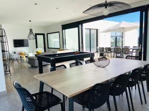 - une salle à manger avec une table de ping-pong et des chaises dans l'établissement Villa Pool and Beach Bretagne, à Plouescat