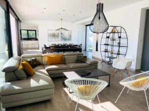 a living room with a couch and a piano at Villa Pool and Beach Bretagne in Plouescat