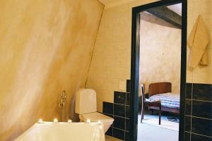 a bathroom with a tub and a toilet and a table at Pivarootsi Windmill in Pivarootsi