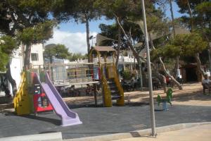 un parque con parque infantil con toboganes y estructura de juegos en Résidence MADRID, en Alcossebre