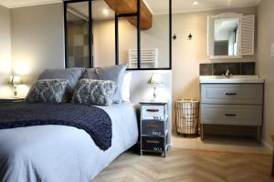 a bedroom with a large bed and a sink at Les maisons de Charlotte (2) in Glanville