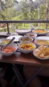 a table with many bowls of food on it at Tea Hills Bungalow in Hatton