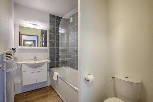 a bathroom with a toilet and a sink and a bath tub at Résidence Azurea in Aix-les-Bains