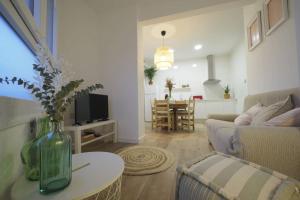 uma sala de estar com um vaso de flores sobre uma mesa em Apartaments Sa Calm La coma em Sant Hilari Sacalm