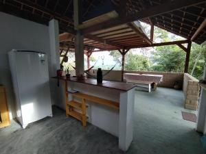 a kitchen with a table and a refrigerator in a room at Kombi Hostel Camping in Vale do Capao
