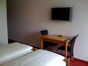 um quarto com uma mesa e uma pequena mesa e uma televisão em Parkhotel Wangs em Wangs