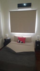a bed with a white blanket on top of it at Hotel Alcaldeza - Garden House in Santo Domingo