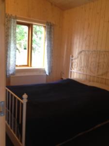 a bedroom with a bed and a window at Cabin 1 at Lundar Farm in Borgarnes