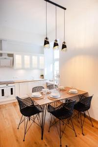 - une cuisine avec une table et des chaises en bois dans l'établissement Lossi 32 Lux Apartment, à Tartu