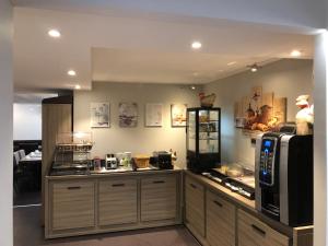 a kitchen with a counter with a microwave and a counter sidx sidx sidx at Savoy Hôtel Evian in Évian-les-Bains