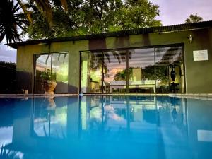 una piscina frente a una casa en Bush Pillow Guest House en Otjiwarongo