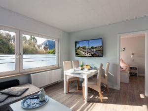 a living room with a table and chairs and a tv at Ferienwohnanlage Lübben in Carolinensiel