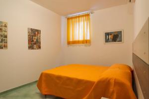 ミントゥルノにあるProcida Apartmentのベッドルーム1室(オレンジ色の毛布付きのベッド1台付)
