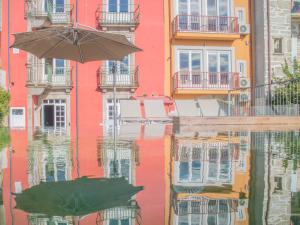 un bâtiment avec un parapluie et sa réflexion dans l'eau dans l'établissement PipaD'oro by YoursPorto, à Porto