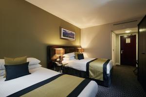 a hotel room with two beds in a room at Stamford Bridge Hotel London in London