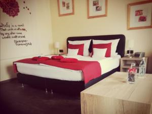 a bedroom with a large bed with red pillows at Henblas Hotel in Altenaffeln
