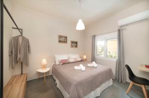 1 dormitorio con 1 cama con 2 toallas en The Dreamhouses by the center, en Agios Nikolaos