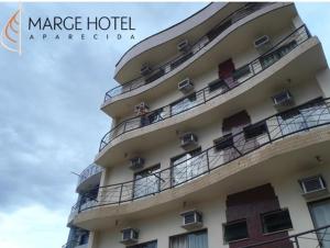 a building with people on the balconies of it at Marge Hotel in Aparecida