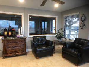 a living room with two chairs and a dresser and mirrors at Americas Best Value Inn Onawa in Onawa