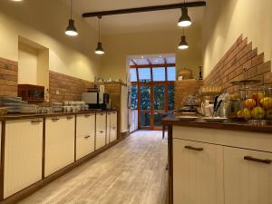 a kitchen with white cabinets and a wooden floor at Avalon Bed & Breakfast Themen/- Nichtraucherhotel in Hannover