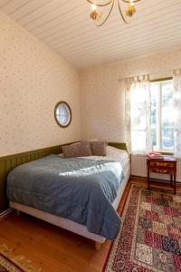 a bedroom with a bed and a window and a rug at Villa Sofia Barösund in Inkoo