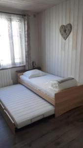 2 camas en un dormitorio con un corazón en la pared en Gîte Chevênes, en Annecy